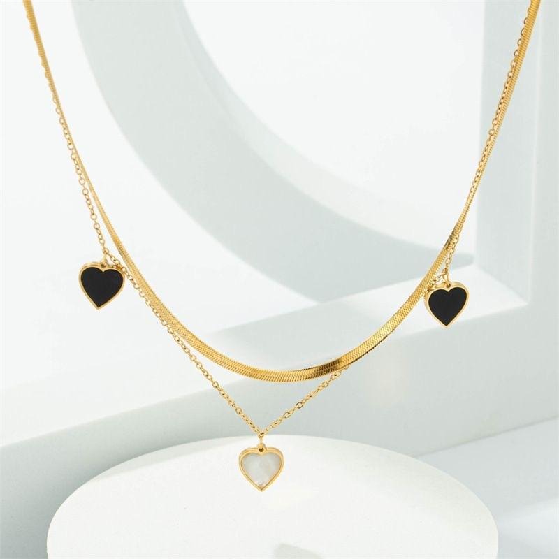 Dual-Layer Golden Necklace with Black and White Heart Pendants