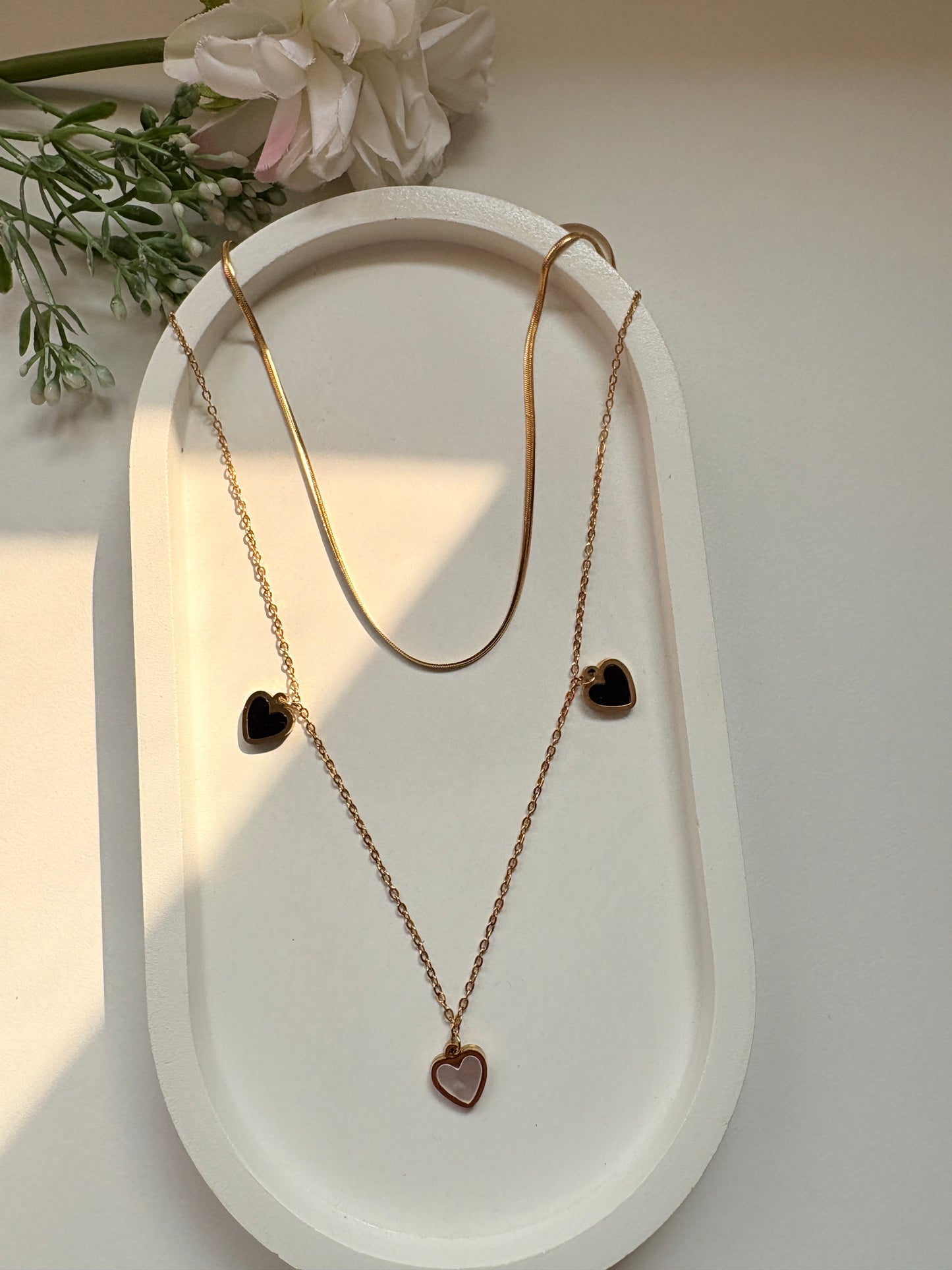 Dual-Layer Golden Necklace with Black and White Heart Pendants