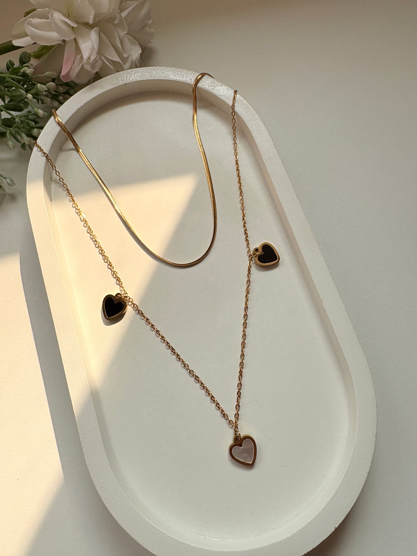 Dual-Layer Golden Necklace with Black and White Heart Pendants